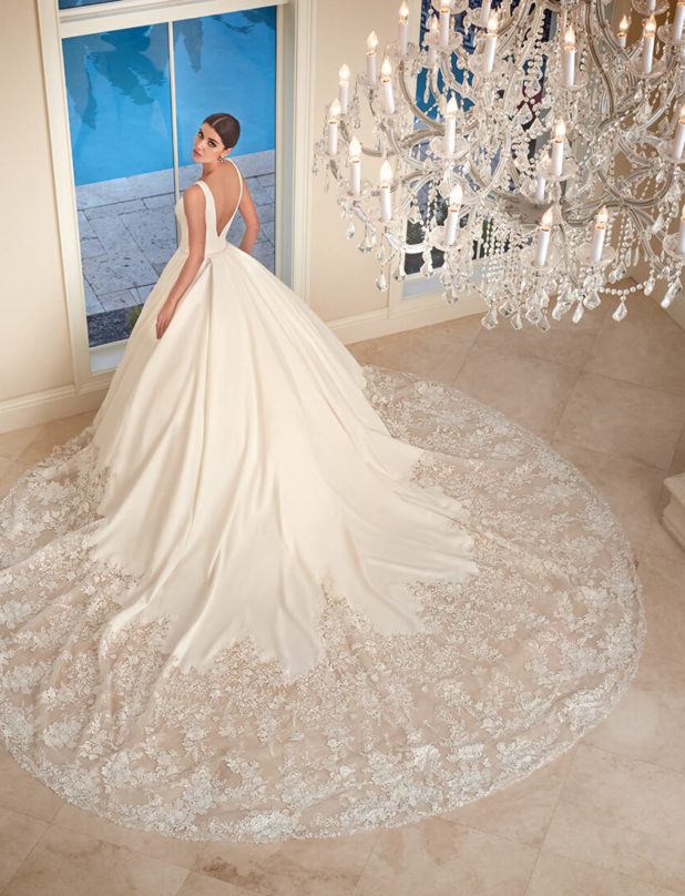 Schwarzhaarige Braut in Brautkleid Prinzessin V-Ausschnitt mit Kronleuchter von oben fotografiert Rückenansicht
