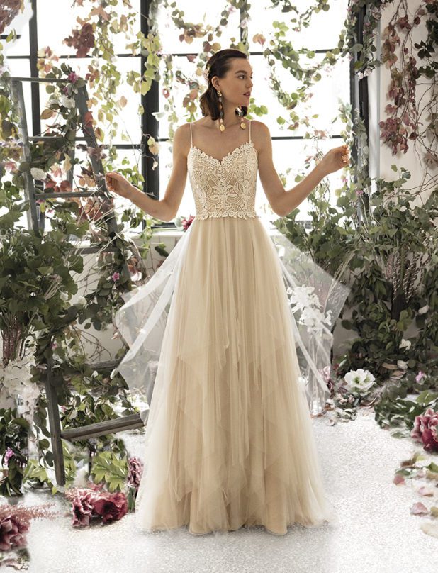 Schwarzhaarige Braut in Vintage Brautkleid ärmellos mit Spaghettiträger und Muster und mit angehobenen Armen