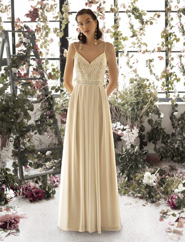 Schwarzhaarige Braut in Vintage Brautkleid ärmellos mit Spaghettiträger mit und Ohrschmuck und Händen hinter dem Rücken