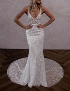 Braut in figurbetontem Brautkleid mit floralen 3D-Applikationen und tiefem V-Ausschnitt, lange Schleppe.