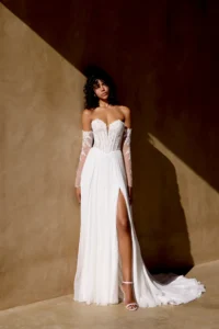 Brautkleid mit Herzausschnitt, transparentem Spitzen-Korsett und abnehmbaren Off-Shoulder-Spitzenärmeln, kombiniert mit fließendem Chiffon-Rock und Beinschlitz, Ganzkörperansicht.